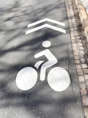 Asfalt yolda yön oklarıyla bisiklet şeridi sembolü.