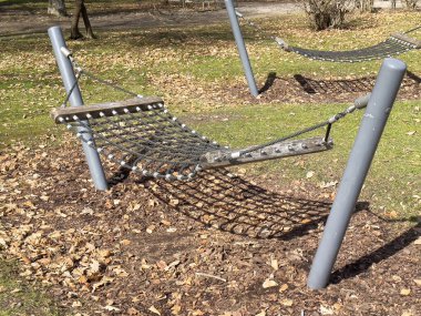 Bahçedeki hamakta çimlerin üzerine düşmüş yapraklar var..