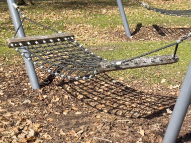 Sonbaharda düşen yaprakların arasında güneş ışığı gölgeli bir hamak.