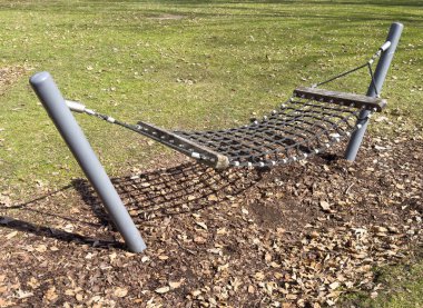 Yeşil yapraklı alanda açık alan halat hamağı..