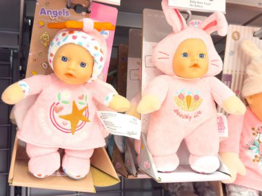 Rafta pembe elbiseli iki bebek ve oyuncakçı dükkanında aksesuarlar..