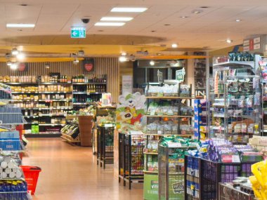 Raflarda çeşitli ürünlerle dolu bir market koridoru.