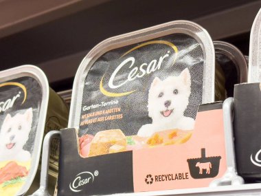Mağaza rafında geri dönüşümlü özelliği vurgulayan Cesar köpek maması ambalajı.