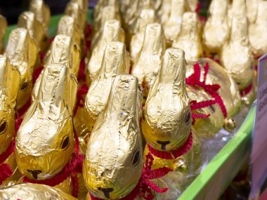 Altın folyolu çikolata tavşancıkları parlak bir ekrana sarılmış..