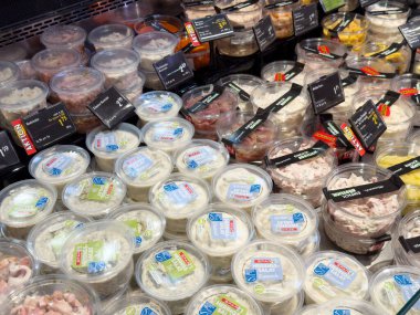 Dondurulmuş vitrinde çeşitli hazır deniz ürünleri ve salata kapları..