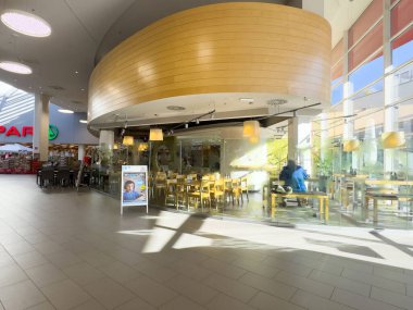 Modern alışveriş merkezinin içi cam cephe ve ahşap tasarım elementleriyle dolu..