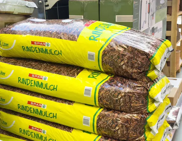 Ağaç kabuğu torbaları bahçe işleri için canlı sarı ambalajlarla dolu koridorda duruyor..