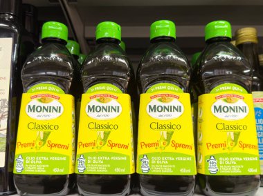 Monini klasik ekstra bakire zeytinyağı şişeleri rafta..