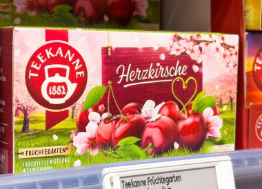 Kiraz sanatı ve kalp sembollü meyve çayı paketi Teekanne kutusunda.
