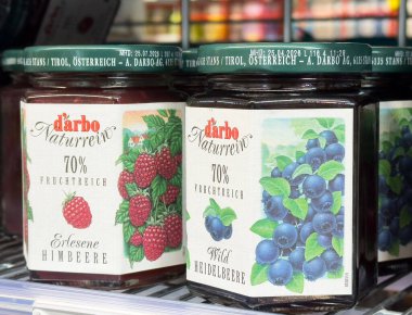 Ahududu ve yaban mersini reçel kavanozları canlı etiketlerle dolu raflarda..