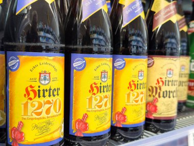 Renkli etiketlerle dolu raflardaki bira şişelerinin çeşitliliği.