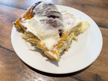 Beyaz tabakta kremalı ev yapımı tarçın ruloları..