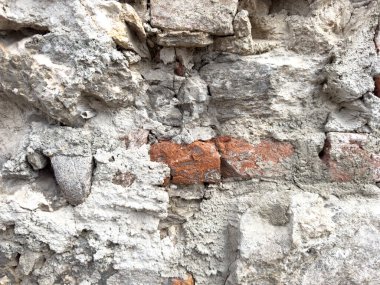 Eskimiş tuğla ve parçalanmış beton duvar dokusu ve karışık taşlar..