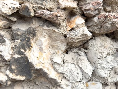 Doğal taş ve beton duvar dokusuna yakın çekim.