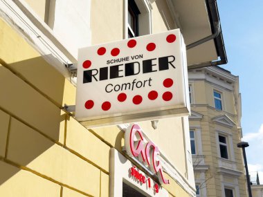 Rieder Schuh mağazası tabelasının dışında sarı noktalar var..