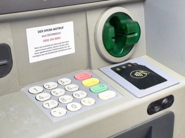 Acil durumda aranacak kişi etiketli ATM ve kart yuvasının yakın görüntüsü.