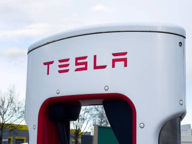 Kentsel alandaki Tesla şarj istasyonu temiz gökyüzü arkaplanına sahip.