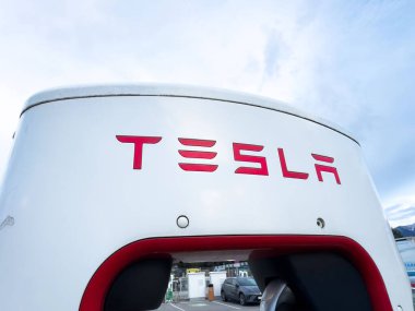 Tesla şarj istasyonu açık havada kırmızı logo ile.