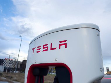 Tesla şehir planına sahip bulutlu gökyüzüne karşı şarj istasyonu.