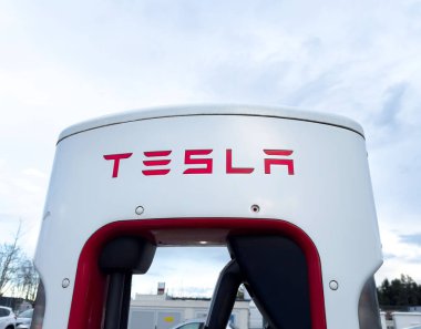 Tesla süper şarj istasyonu bulutlu gökyüzü arka planına sahip.