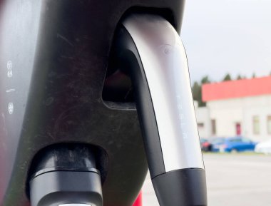 Tesla elektrikli araba şarj cihazının kentsel ayarlarda takılı olduğu yakın plan.