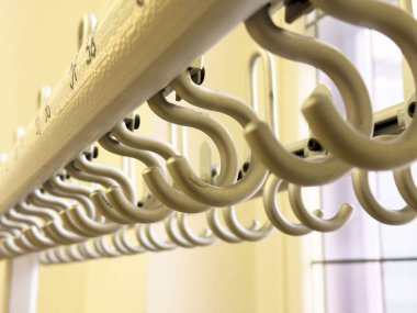 Beyaz sarmal kancaları parlak iç mekâna asmanın soyut bir düzeni..