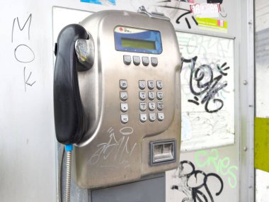 Şehir merkezinde graffiti olan eski bir ankesörlü telefon..