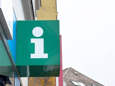 Gökyüzü arka planına sahip şehir binasının dış yüzeyi hakkında yeşil bilgi işareti.