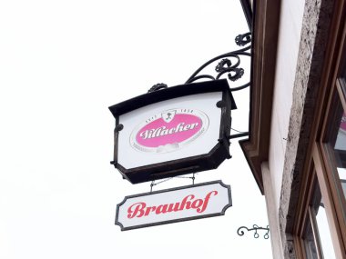 Şehir merkezinde berrak gökyüzüne asılı eski bir bar tabelası..