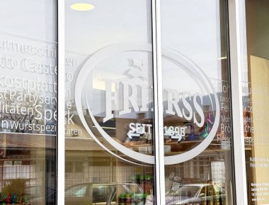 Almanca metin ve yansımaları olan kasap dükkanı penceresi.