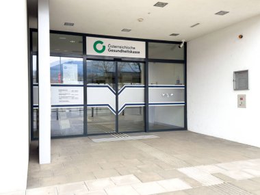 Camdan kapıları olan modern Avusturya sağlık sigortası binasına giriş..