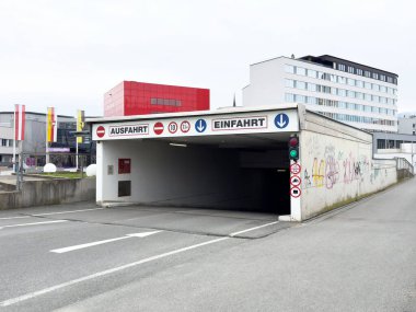 Yeraltı otoparkının girişi ve çıkışı tabela ve duvar yazısıyla dolu..