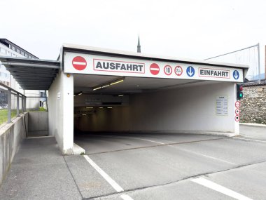 Şehir merkezinde trafik işaretleriyle yeraltı otoparkı girişi ve çıkışı..