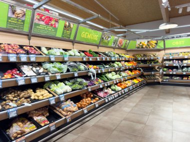 Süpermarket koridorunda sebze ve meyveli taze ürün sergileniyor..