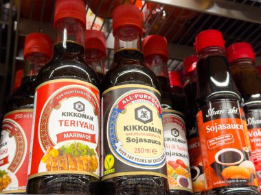 Dükkanda çeşitli kikkoman soya sosu şişeleri.