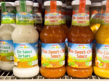 Raftaki organik sos şişeleri: tartar ve tatlı biber çeşitleri.