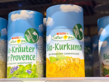 Rafta organik zerdeçal ve baharat kavanozları var..