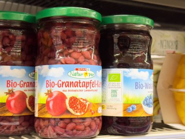 Süpermarketin rafında organik nar ve yabanmersini kavanozları.