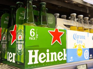 Süpermarket raflarında Heineken ve Corona bira paketleri.