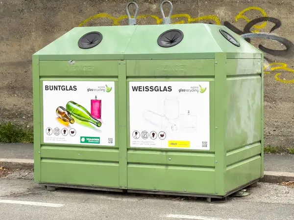 Şehir caddesinde cam öğütücü için yeşil geri dönüşüm kutuları.