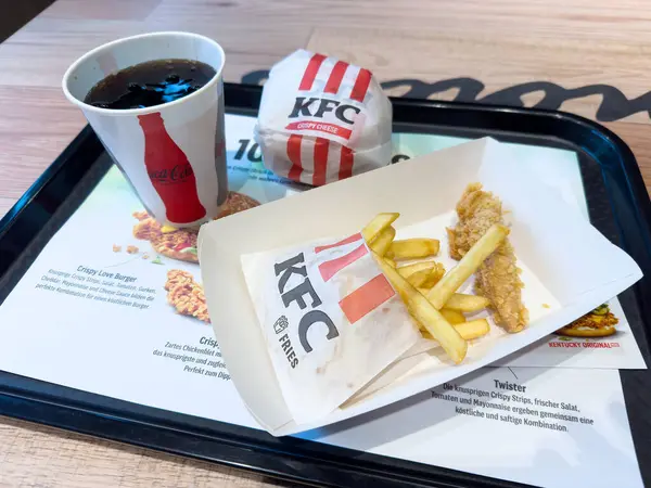 KFC yemeği, çıtır tavuklu sandviç, patates kızartması ve tepside meşrubat..