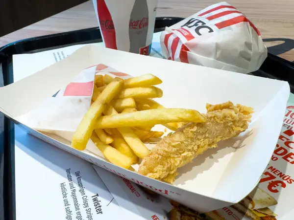 Kızarmış tavuk, patates kızartması ve tepside meşrubat ile fast food..