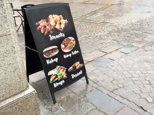 Çerezler, kebaplar, ambalajlar ve yağmurlu kaldırım taşlarıyla ilgili tatlı seçenekleri olan sokak yemekleri sergisi..
