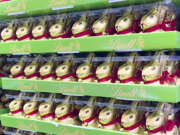 Sıralar dolusu altın folyoya sarılı çikolata tavşancıkları ve kırmızı kurdeleler..