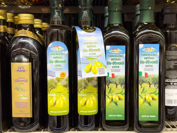 Süpermarketin rafında ekstra bakir zeytinyağı şişeleri var..