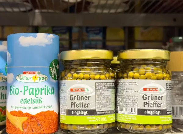 Rafta biyo-biber ve yeşil biber kavanozları olan organik baharat seçimi.
