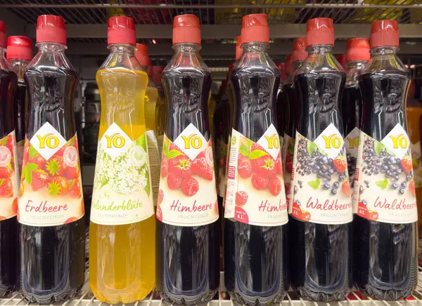 Mağaza rafında çeşitli aromalar içeren renkli meyve şerbetleri var..