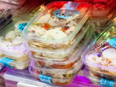 Piyasada sergilenen plastik ambalajda taze deniz ürünleri seçimi.