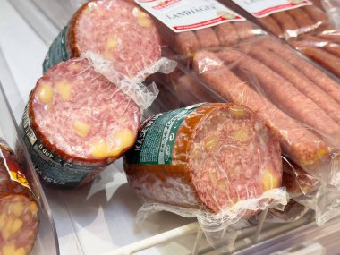 Bir vitrinde paketlenmiş sosis ve peynir salamı çeşitleri.