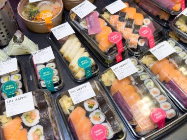 Çeşitli suşi dürümleri: plastik kaplarda taze nigiri, maki ve sashimi..